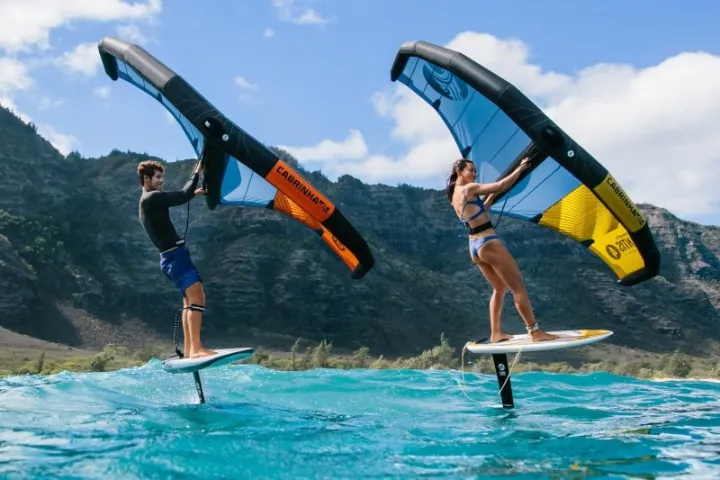 a man flying through the air while riding a surfboard in the water